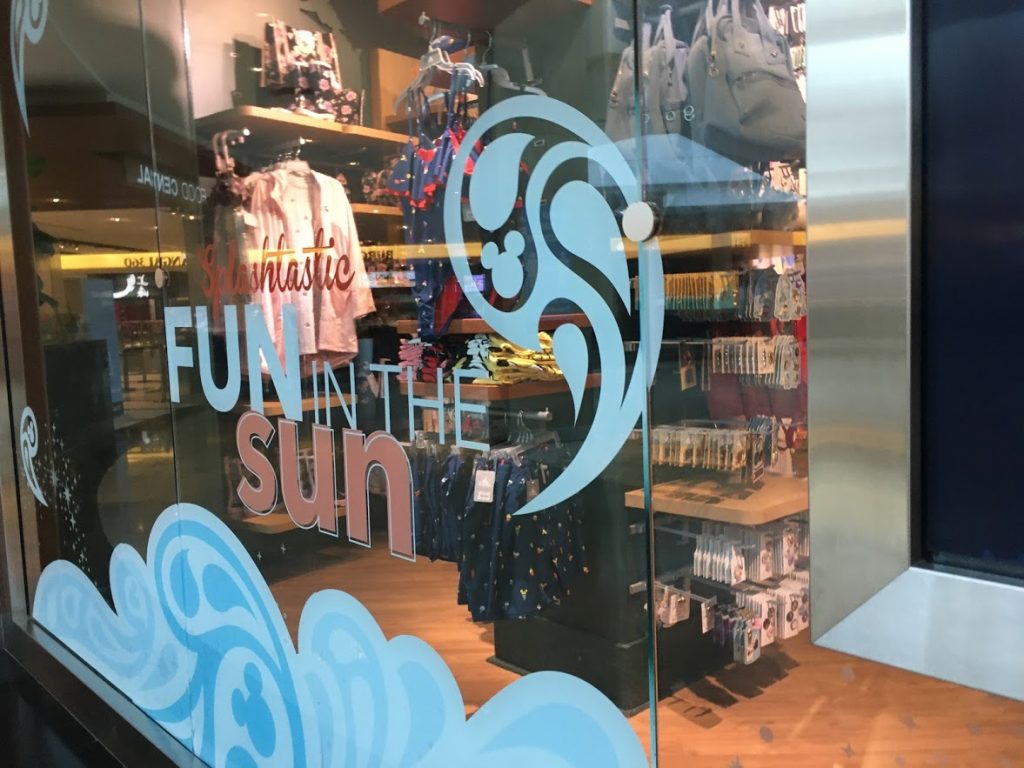 An angled view of the words "Splashtastic Fun in the Sun" on a store window.