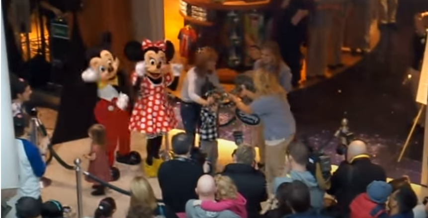 Mickey and Minnie cheer at a key ceremony.