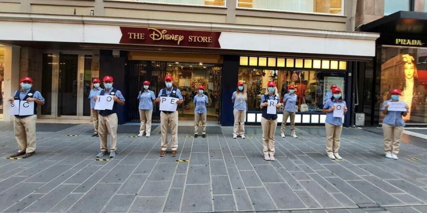 People stand in a row outside a Disney Store.