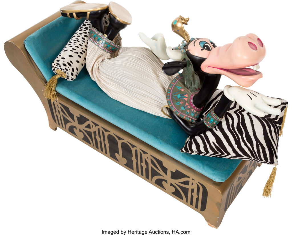 An anthropomorphic cow lies on her stomach, dressed as Cleopatra.