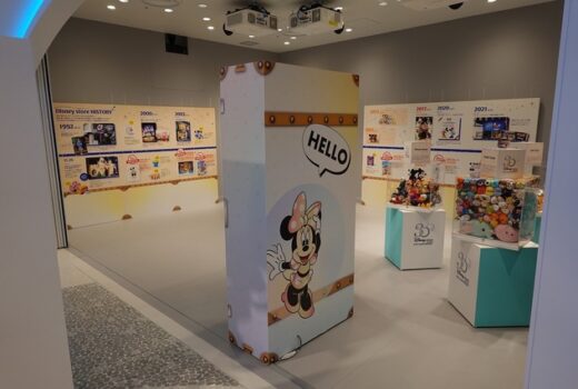 A room with pictures on the wall, and a large bulkhead at the front with an image of Minnie Mouse. Smaller cases within.