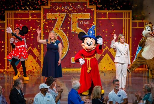 Mickey, Minnie, a chipmunk, and two humans on a stage.