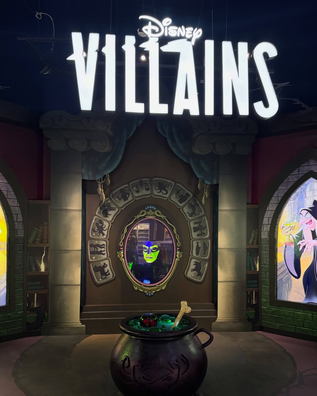 The words "Disney Villain" on top of a display with the menacing Magic Mirror from Snow White.