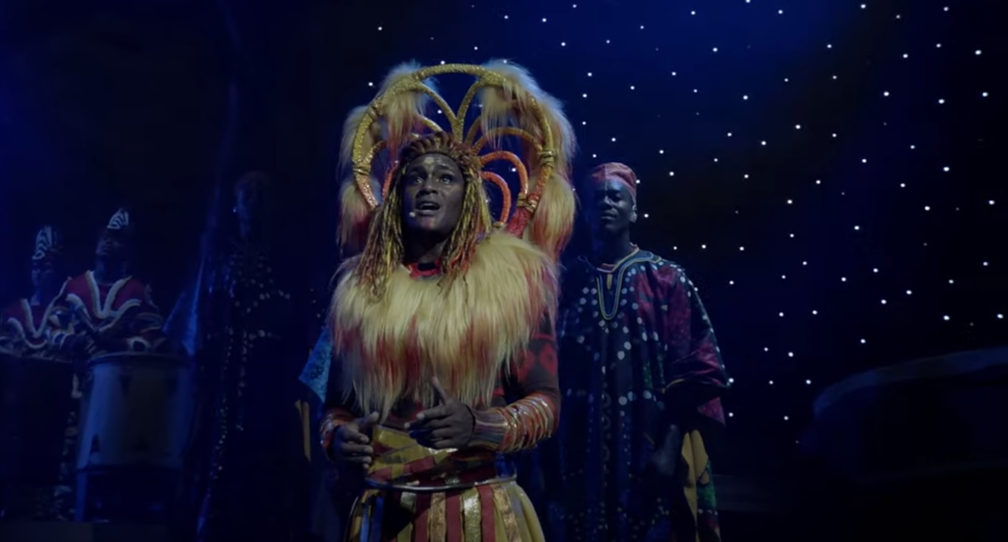 A man dressed a lion, looks wistfully.