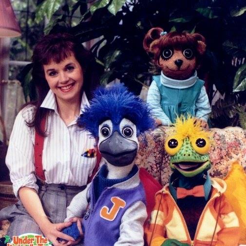 A woman, and puppets of a bird, a lizard, and a gopher