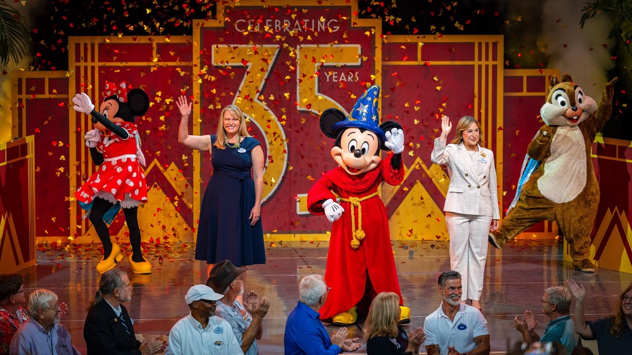 Mickey, Minnie, a chipmunk, and two humans on a stage.