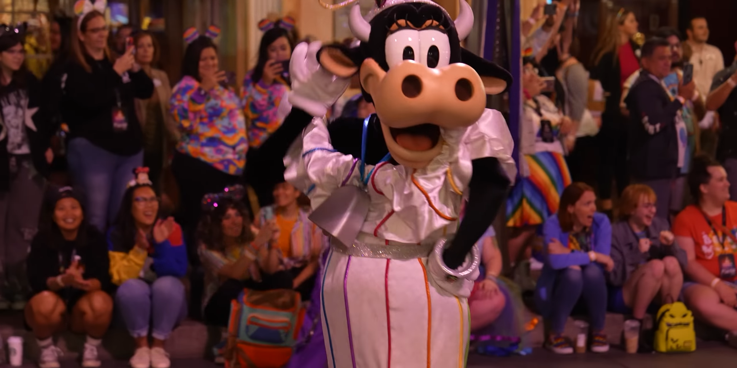 A cow mascot fluffs her non-existent hairdo.