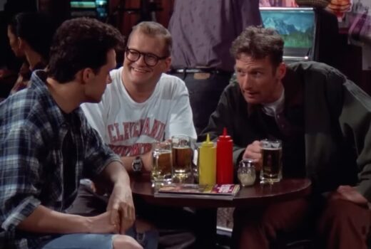 Three men around a table, in a bar.