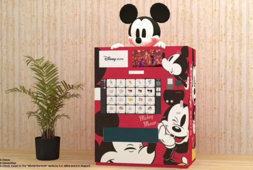 A red vending machine with Mickey multiple times on it, large, and a Mickey head above.