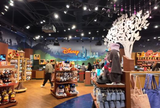 The interior of a themed store, with the word Disney in red lights on the wall.