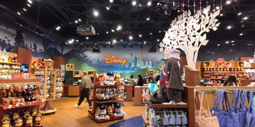 The interior of a themed store, with the word Disney in red lights on the wall.