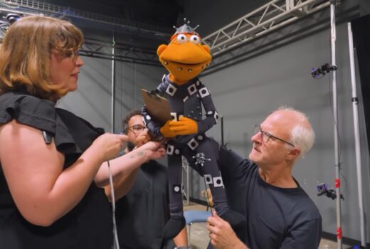 A puppeteer performs while people look on.