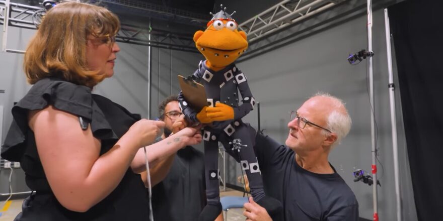 A puppeteer performs while people look on.