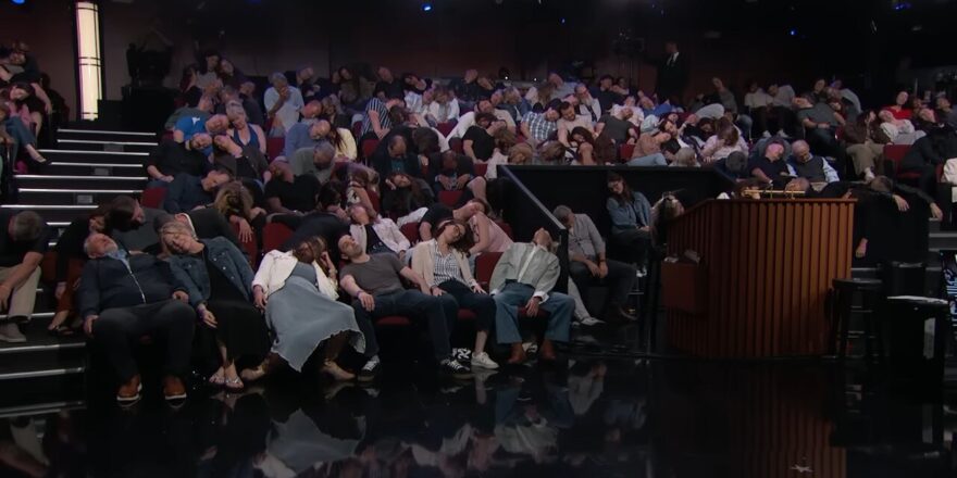 A crowd all flops over in their seats.