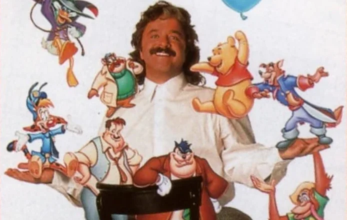 A man sits on a chair, surrounded by cartoon characters.