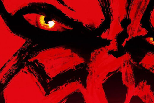 Close up on the eyes of a man with red and black face tattooing.